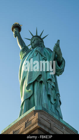 Blick auf die ganze Statue of Liberty von unten mit einem wolkenlosen blauen Himmel. Stockfoto