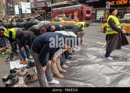 New York, Vereinigte Staaten von Amerika. 17. Januar 2016. Eine Gruppe von muslimischen Männern unter den Teilnehmern an der Rallye führte beten, von Zak Al-Kaysi (rechts), einer der Teilnehmer aus einem Kontingent von Pennsylvania. Fast sammelten 1000 Mitglieder der Muslim-amerikanischen Gemeinschaft aus New York, Illinois und Michigan am Times Square gegen den Saudi-arabischen Regierung den letzten Ausführung des schiitischen Kleriker Scheich Nimr al-Nimr und 46 Anhänger, das jüngste Massaker in Zaria, Nigeria und die ausstehende Ausführung von Sheikh Ibrahim Zakzay. Bildnachweis: Albin Lohr-Jones/Pacific Press/Alamy Live-Nachrichten Stockfoto