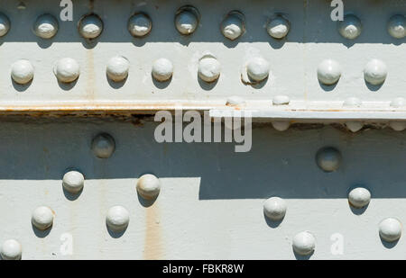 Close-up von Nieten auf lackierten Oberflächen mit einige Rostflecken, teilweise Casting Shadows von oben. Stockfoto