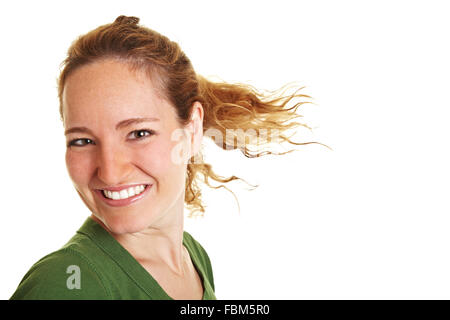 Glückliche junge Frau mit ihren brünetten Haaren im wind Stockfoto
