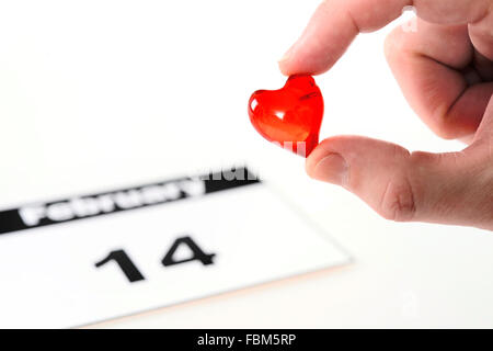 Valentinstag-Kalenderseite und Mann mit roten Herzchen Stockfoto