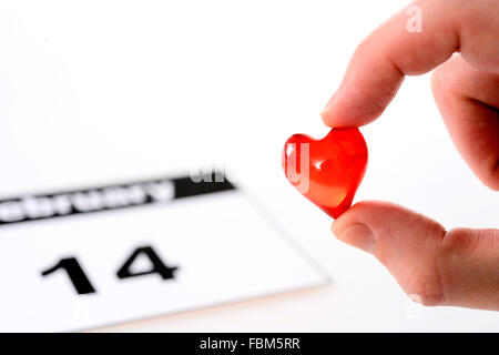 Valentinstag-Kalenderseite und Mann mit roten Herzchen Stockfoto