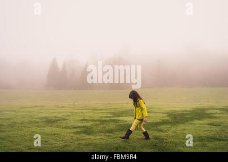 Seitenansicht eines Mädchens zu Fuß im Park an einem nebeligen Tag Stockfoto