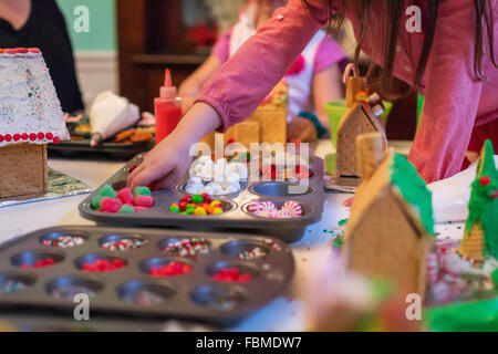 Kinder verzieren Lebkuchenhäuser Stockfoto