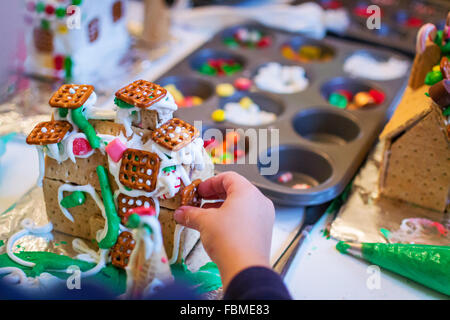 Junge dekorieren ein Lebkuchenhaus Stockfoto