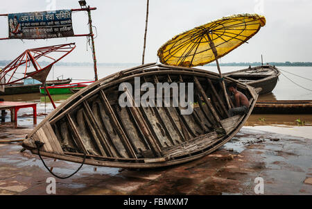 Ein Mann repariert Flut beschädigte Boot am Ufer des Ganges nach Monsun-Regen. Stockfoto