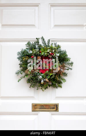 Weihnachtskranz an der Haustür aufhängen Stockfoto