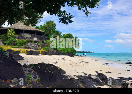 Gäste entspannen, Flanieren entlang der Sandstrand Vorland im Pacific Resort Aitutaki. Aitutaki Cookinseln Südsee Stockfoto