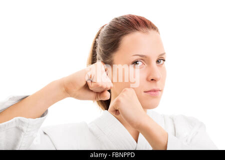 Ich kann mein Selbst. Nahaufnahme von einem jungen Mädchen mit Kimono in Kampfstellung, auf weißem Hintergrund. Stockfoto