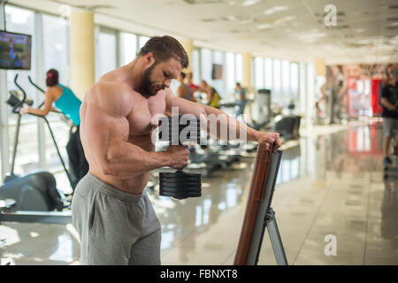 Brutaler Mann im Fitness-Studio. Stockfoto