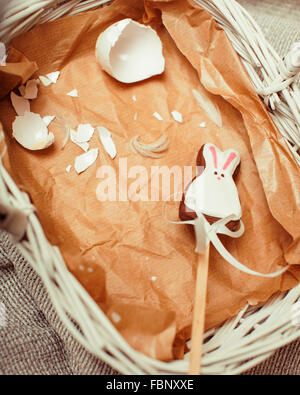 Feier für die Osterkarte, Candy Spielzeug Hase mit stürzte Ei auf Papier im Korb Vintage braun Stockfoto