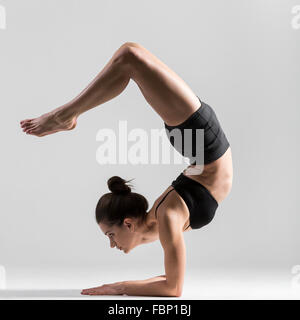 Schöne sportliche Yogi Mädchen praktiziert Yoga Asana, Pincha Mayurasana, Unterarm Stand, gefiederten Pfau Pose, Ellenbogen Gleichgewicht Stockfoto