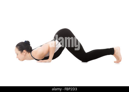 Sportliche Yogi Mädchen Fitness Übungen im Yoga Asana Astangasana, Eight-Limbed Pose, isoliert auf weißem Hintergrund Stockfoto