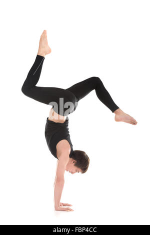 Sportlicher junger Mann, Sport, Tanz, Yoga, Pilates, Fitness-Training, gebogenen Beinen Hirsch Handstand, Seitenansicht, in voller Länge zu tun Stockfoto