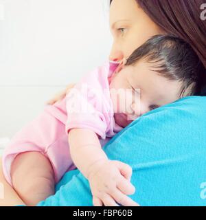Seitenansicht der Mutter Holding niedlichen Baby vor weißem Hintergrund