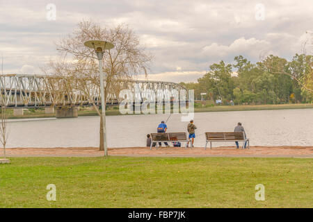 MONTEVIDEO, URUGUAY, Mai - 2015 - Vater und seinen Kindern Angeln am Fluss Küste von Santa Lucia in einem kleinen Dorf in der Organisationseinheit Stockfoto