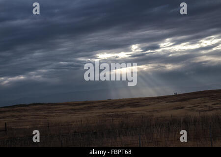 Strahlen der Sonne bricht durch die Wolken über die Prärie Stockfoto