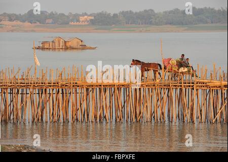 Überladener Pferdewagen überquert die Bambusbrücke auf dem Mekong Fluss (Hausboot im Hintergrund), Kampong Cham City, Kambodscha. Quelle: Kraig lieb Stockfoto