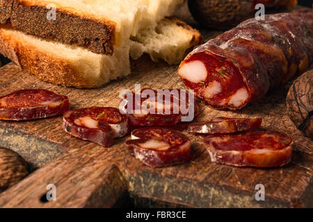 Italienische Wurst mit Brot auf Holzbrett Stockfoto