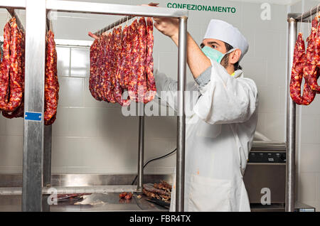 Metzger hängt die italienische Wurst zum Würzen Stockfoto