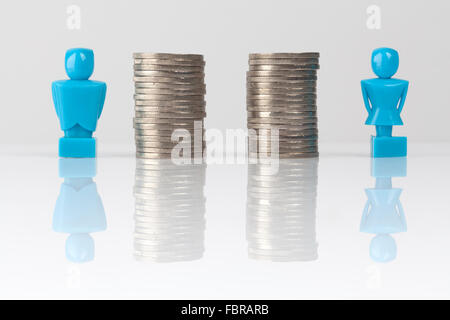 Männliche und weibliche Figuren stehen neben gleich haufenweise Münzen. Einkommen-Gleichheit-Konzept. Stockfoto
