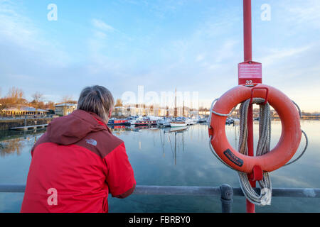 Mann im roten Mantel und Blick auf die Marina Preston in Lancashire Stockfoto