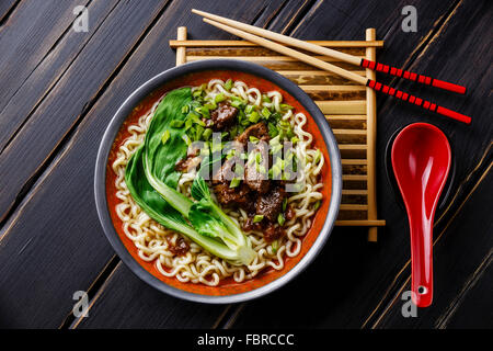 Miso Ramen asiatische Nudeln mit Rindfleisch und Pak Choi Kohl auf dunklem Holz Stockfoto