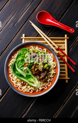 Miso Ramen asiatische Nudeln mit Rindfleisch und Pak Choi Kohl auf dunklem Holz Stockfoto