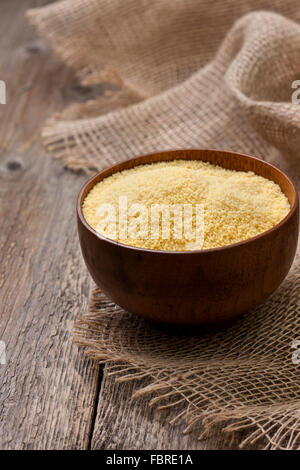 Couscous in einer Holzschale auf einem hölzernen Hintergrund Stockfoto