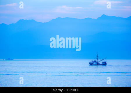Fischerei Trawler in der Abenddämmerung in Straße von Juan De Fuca mit Hintergrund der Olympischen Range, Vancouver Island, Kanada Stockfoto