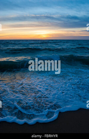 Farbenprächtigen Sonnenuntergang über dem Meer mit Wellen brechen sich am Ufer an Herring Cove Beach, Cape Cod, Massachusetts. Stockfoto