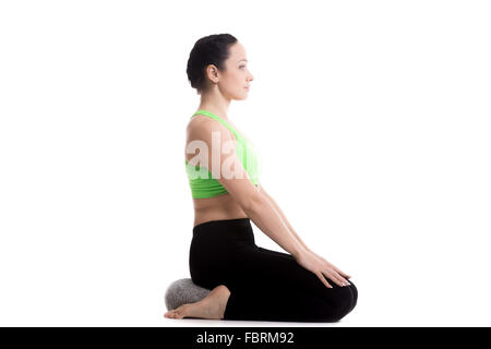 Gelassene Mädchen Yoga zu praktizieren, sitzen auf Kissen in Virasana, Helden darstellen, Asana für Beine, Atmung, Meditation, Pranayama Stockfoto