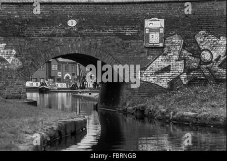 Coventry Canal Basin wie durch ein Graffiti überdachte Brücke Nummer 1 gesehen. Stockfoto