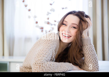 Glücklich entspannt schöne junge Frau in Beige gestrickte Jacke zu Hause sitzen Stockfoto