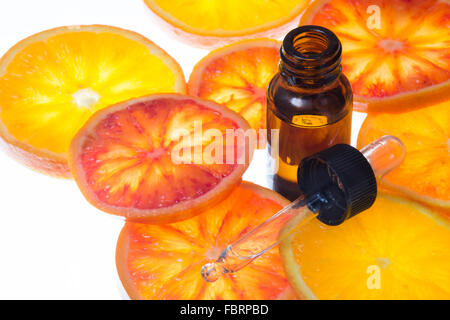 Ätherischen Orangenöl mit gelben Flasche mit frischem Blut orange Scheiben Stockfoto