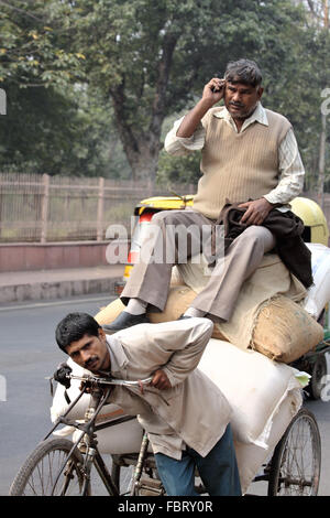 Fahrrad-Rikscha-Mann und seine Kunden in Agra, Indien. Stockfoto