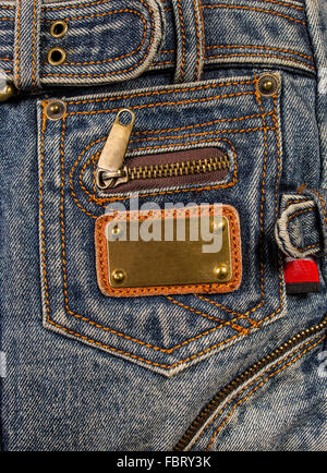 Hintergrund hell Textur Jeans mit gelben Nähten und Metallschild Stockfoto