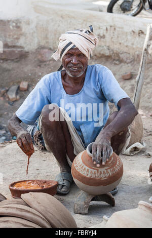 Indische Handwerker schmücken einen Topf in der Nähe von Khajuraho - Madhya Pradesh, Indien. Stockfoto