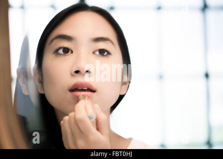 Frau Auftragen von Lippenstift Stockfoto