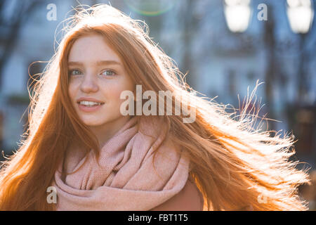 Porträt einer glücklichen Frau mit langen Rothaarige Haare stehen im freien Stockfoto