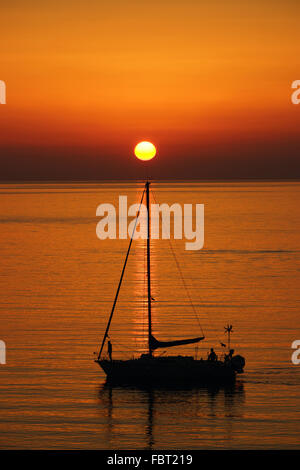 Silhouette der Yacht mit Sonne und ruhige See einstellen Stockfoto