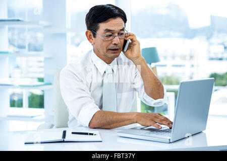 Beschäftigt asiatischen Geschäftsmann am Laptop arbeiten und mit der Aufforderung Stockfoto