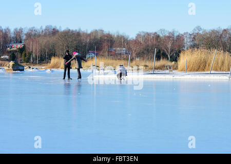 Listerby, Schweden - 17. Januar 2016: Drei unbekannte Personen fotografieren, Eislaufen in der Nähe ein Pier beteiligt sind. Echte Menschen in Stockfoto
