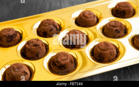 Pralinen mit Kakaopulver in goldenes Paket Stockfoto