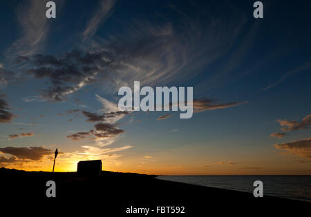 Silhouette eines auf einem Strand in Norfolk, England, UK, bei Sonnenuntergang Stockfoto