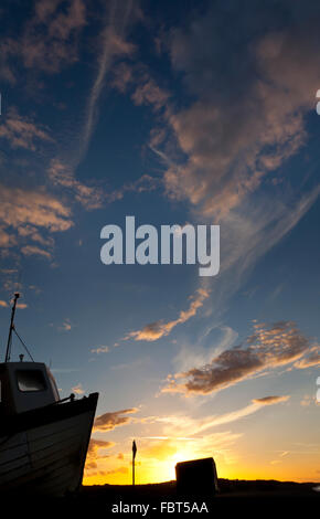 Ein Fischerboot am Strand von Weybourne, Norfolk, England UK bei Sonnenuntergang Stockfoto