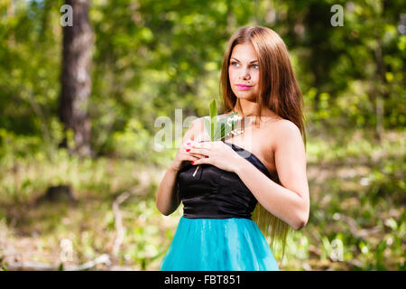 Lang - Haar Mädchen Wald Porträt mit Mai-Lilie. Stockfoto