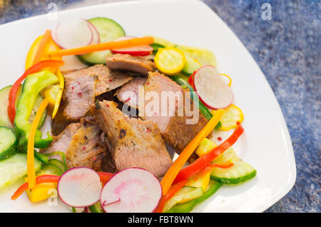 Köstliche Flanke Steak schneidet perfekt zubereitet, gemischt mit rötlich, Zucchini und Paprika, elegante Präsentation Stockfoto