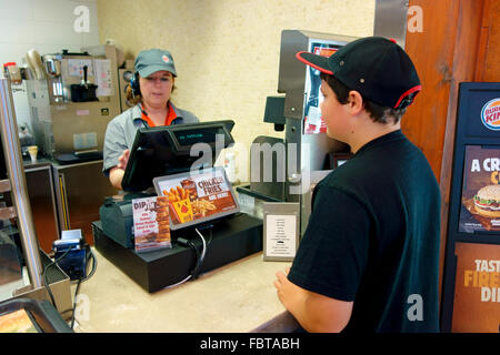 Ein 10 Jahre alter Junge Bestellung Fastfood in einem Burger King-outlet Stockfoto