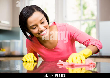 Lächelnde Brünette Reinigung Küchentheke Stockfoto